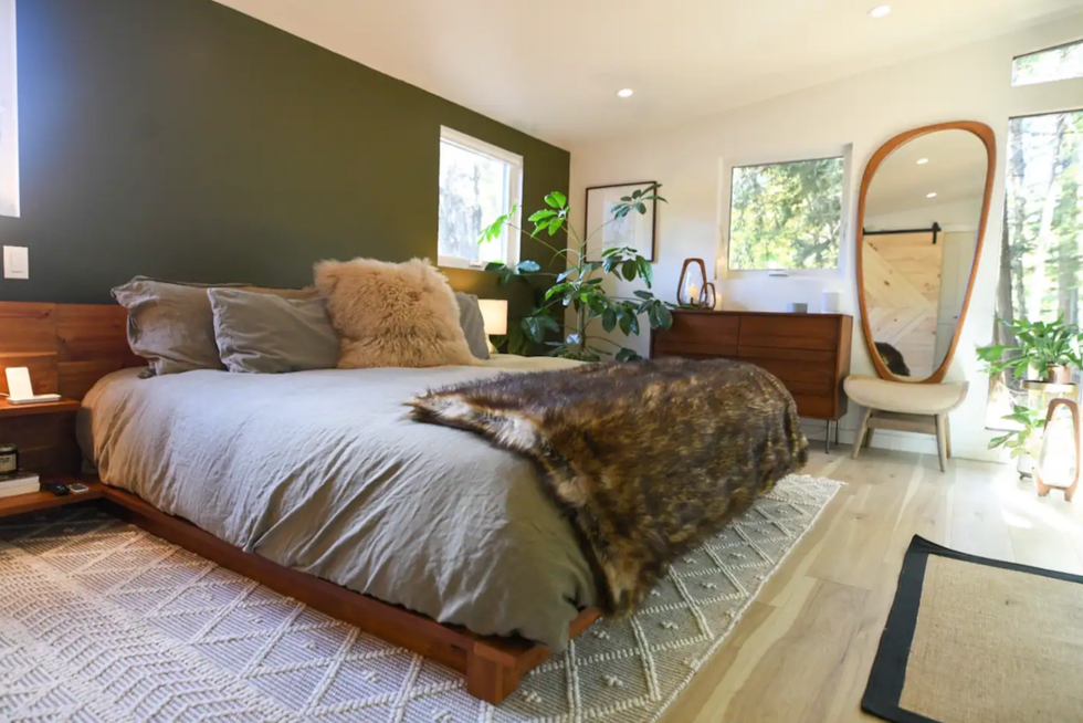 Bedroom with fur throw and pillow.