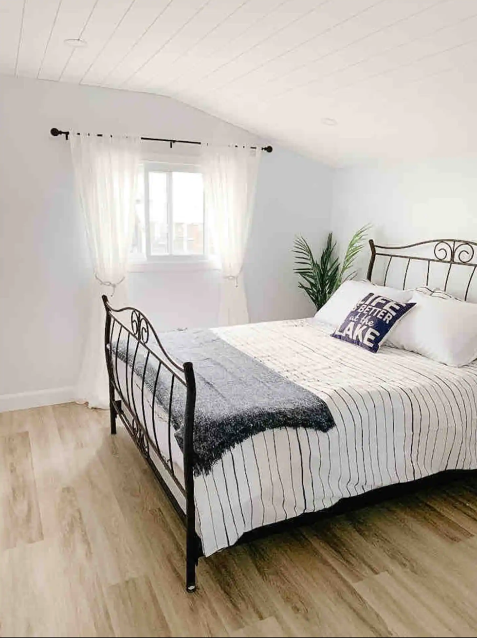 Bedroom with striped sheets.\u200b