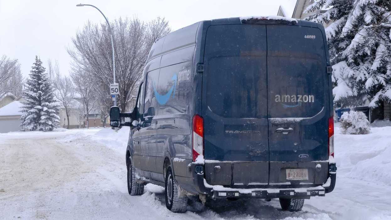 blue amazon prime truck on snow covered street in alberta canada