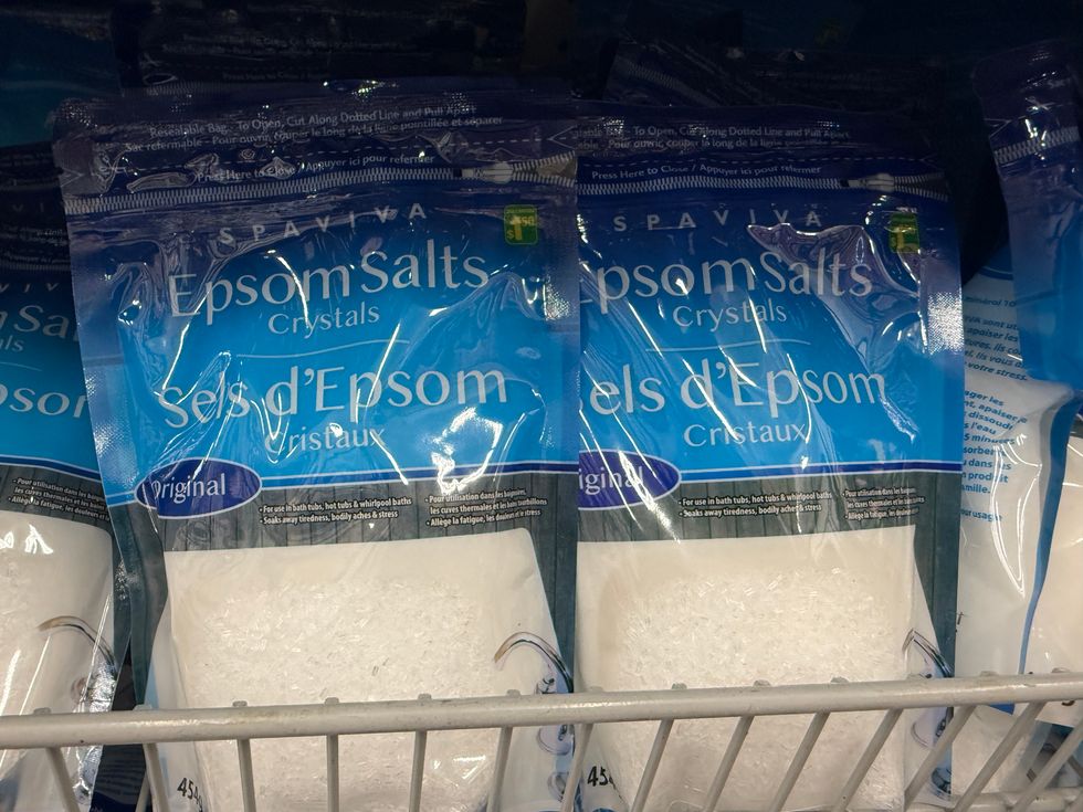 Blue and white bags with the words Epsom Salts Crystals on a store shelf.