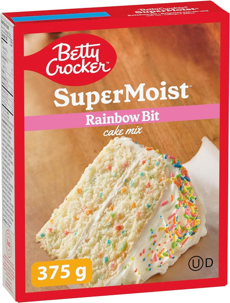 Boite de m\u00e9lange \u00e0 g\u00e2teau Super Moist de la marque Betty Crocker aux brisures arc-en-ciel, sur fond blanc.