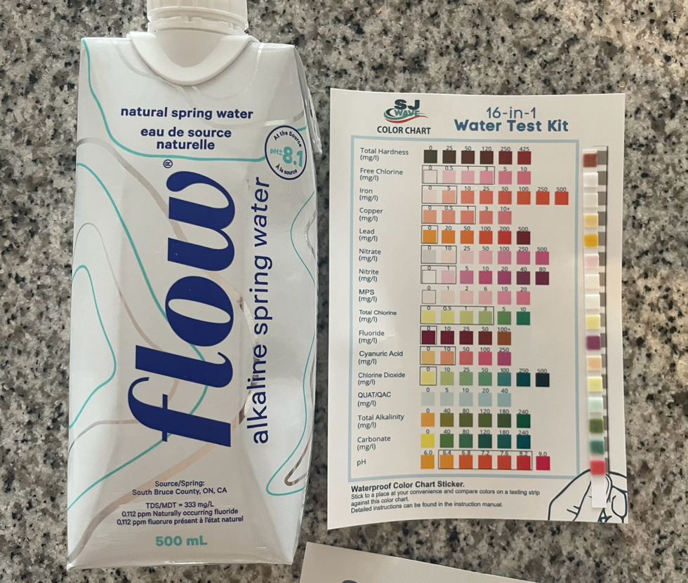 bottle of Flow water next to the results of the water test