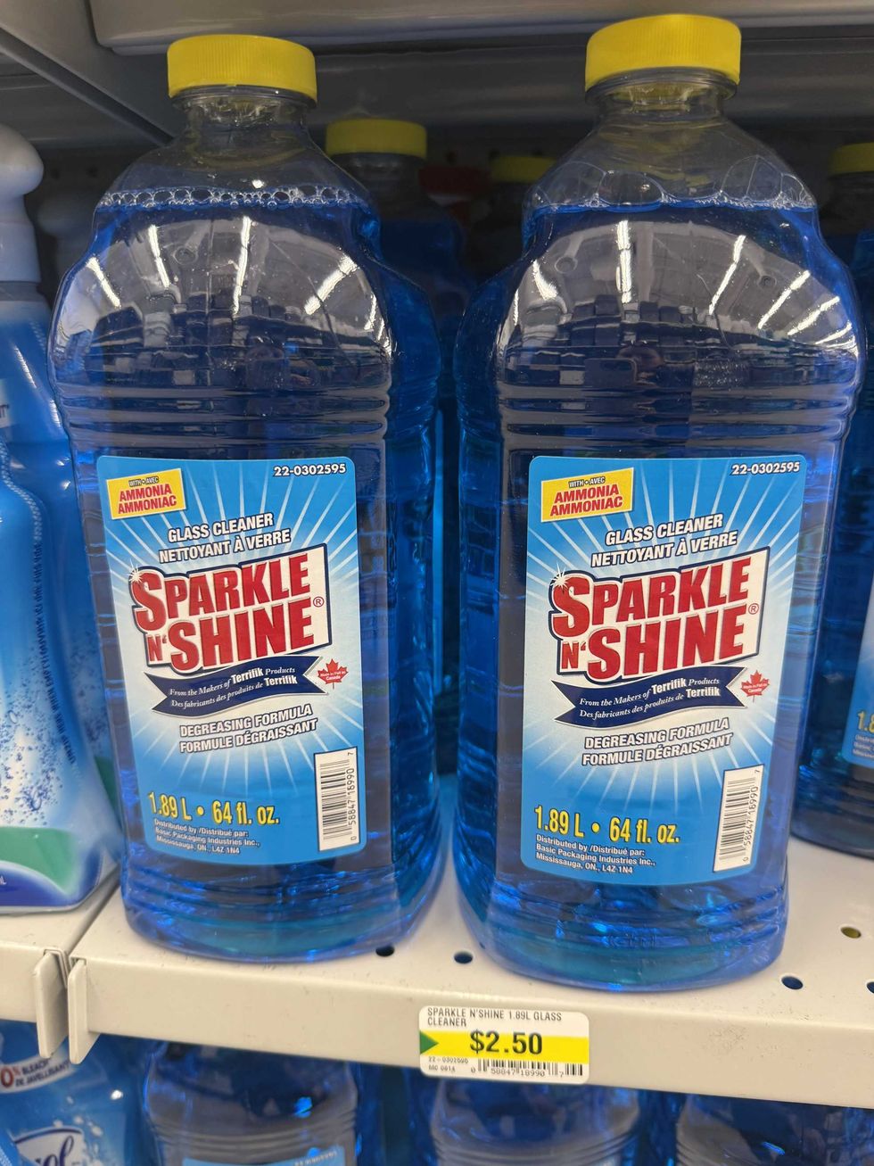 Bottles on a store shelf that have blue liquid in them.