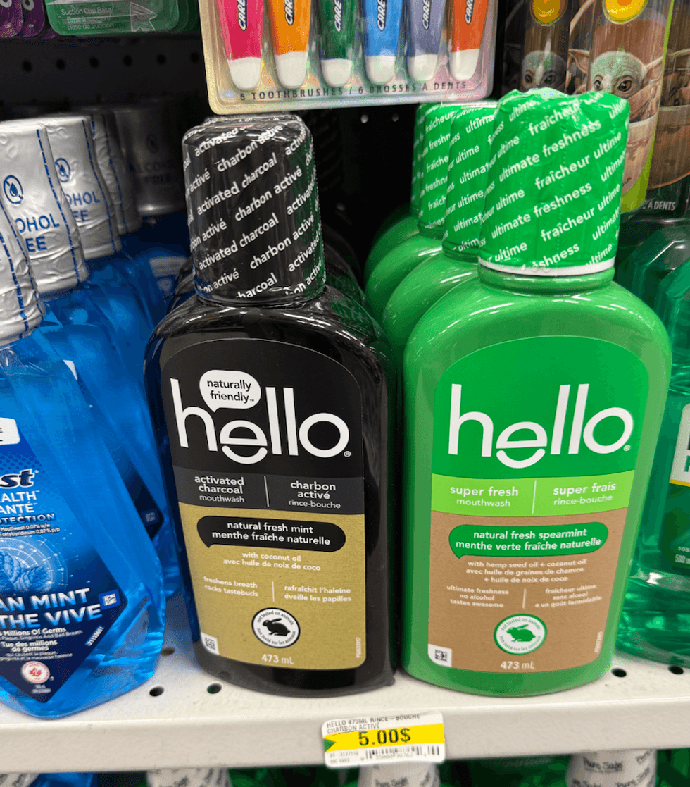 Bouteilles de rince-bouche Hello (charbon actif et menthe verte) sur une tablette de Dollarama.