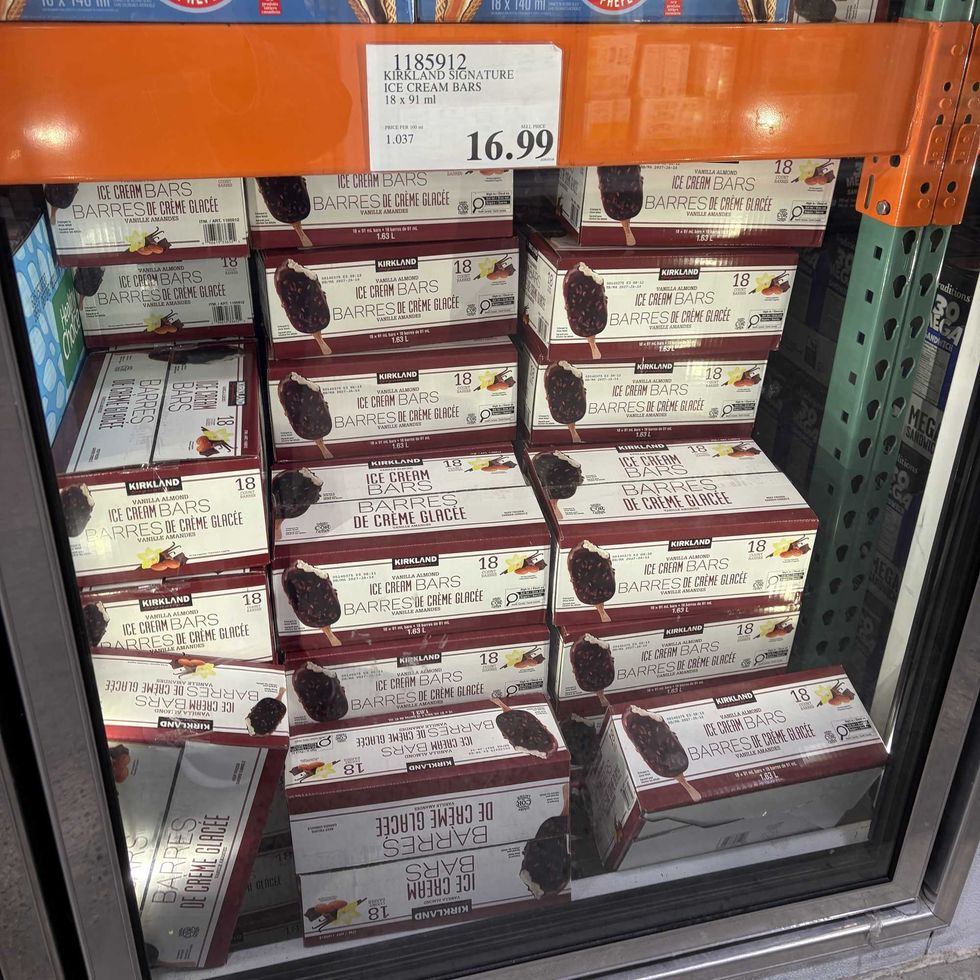 boxes of Kirkland Signature vanilla almond ice cream bars in freezer at costco