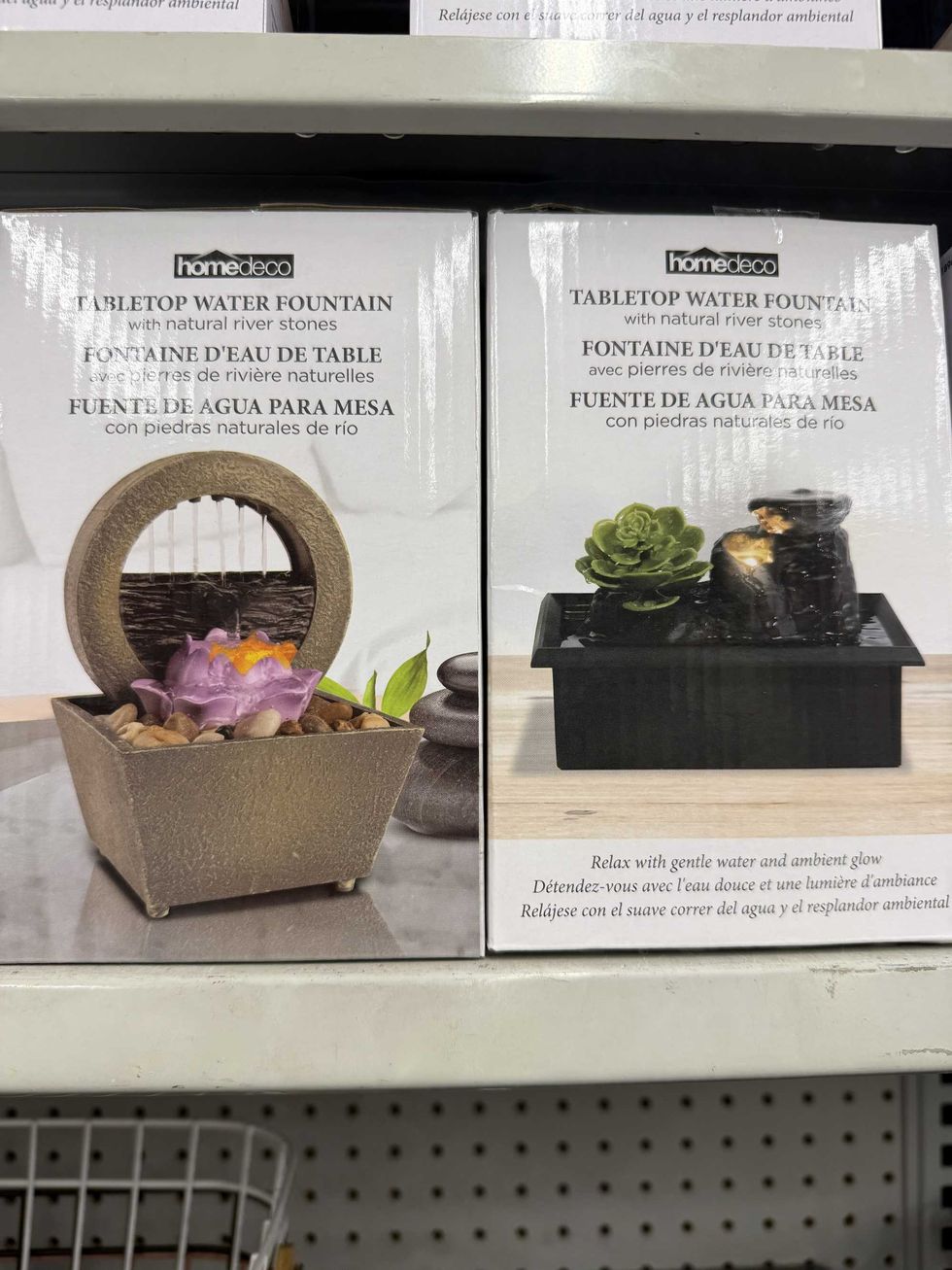 Boxes with photos of small fountains on the front and labels reading tabletop water fountain with natural river stones.