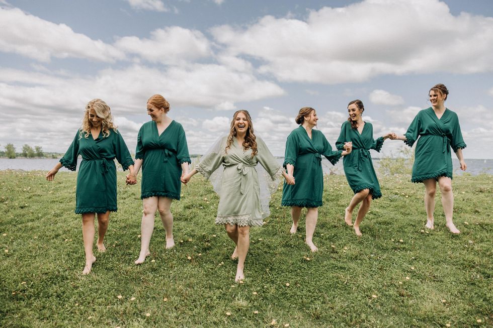 Bride and bridesmaids walking outside in green robes from the store Never Knew I Needed.