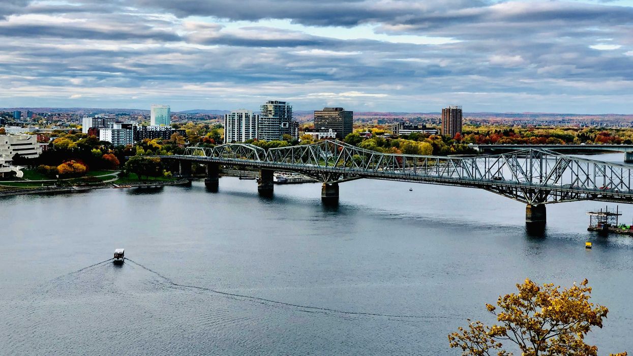 bridge over a river in ottawa with buildings in the background