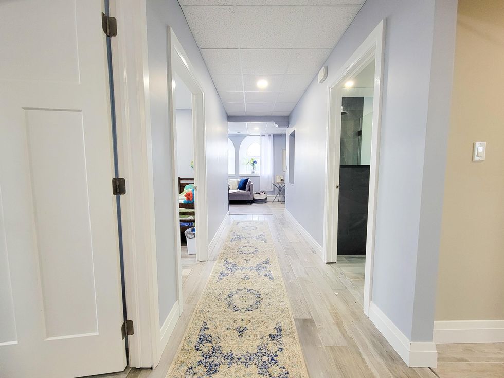 Bright hallway of the house's lower level with multiple bedrooms.