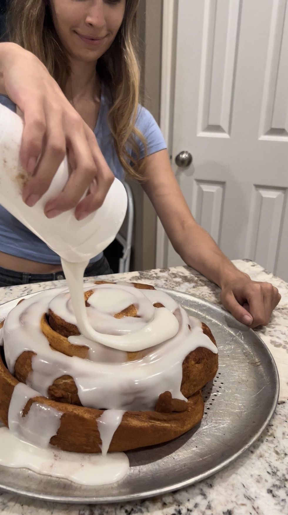 Brittany Cristiano pouring the icing on the 5-pound cinnamon roll.