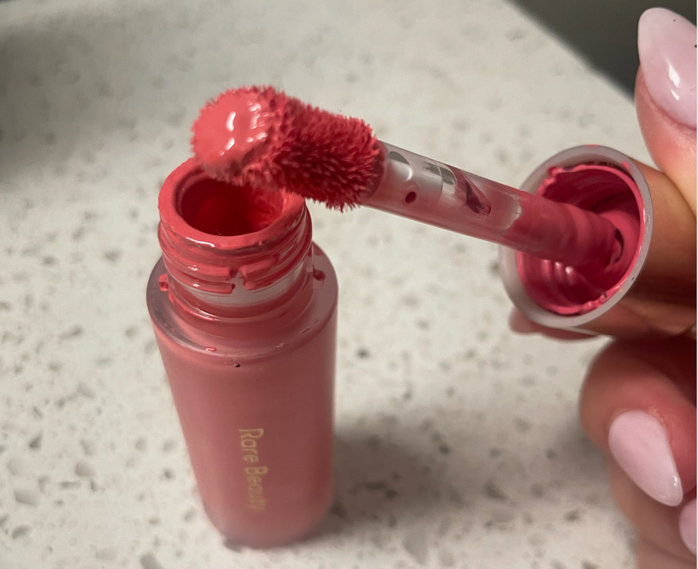 Brooke Houghton holding a Rare Beauty blush.