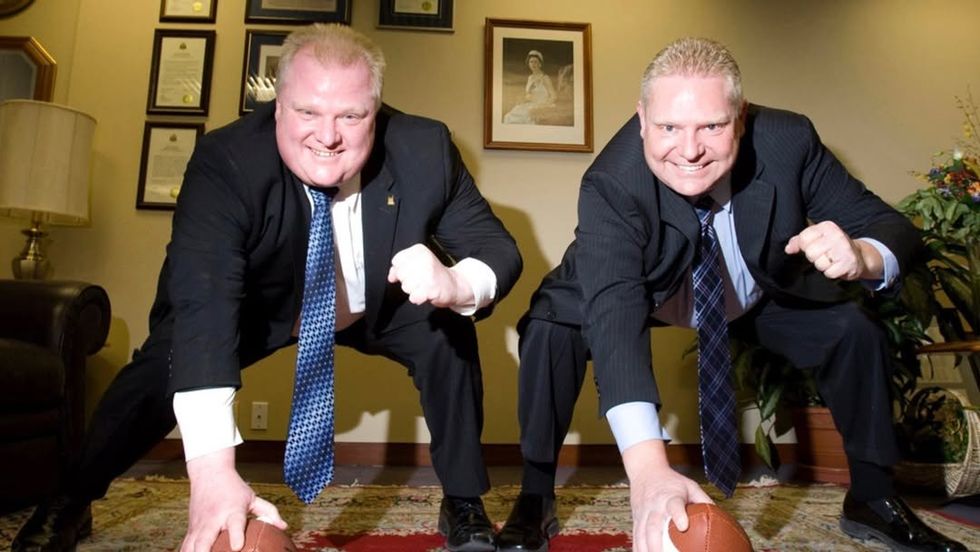 Brothers Rob and Doug Ford mimicking hiking a football.