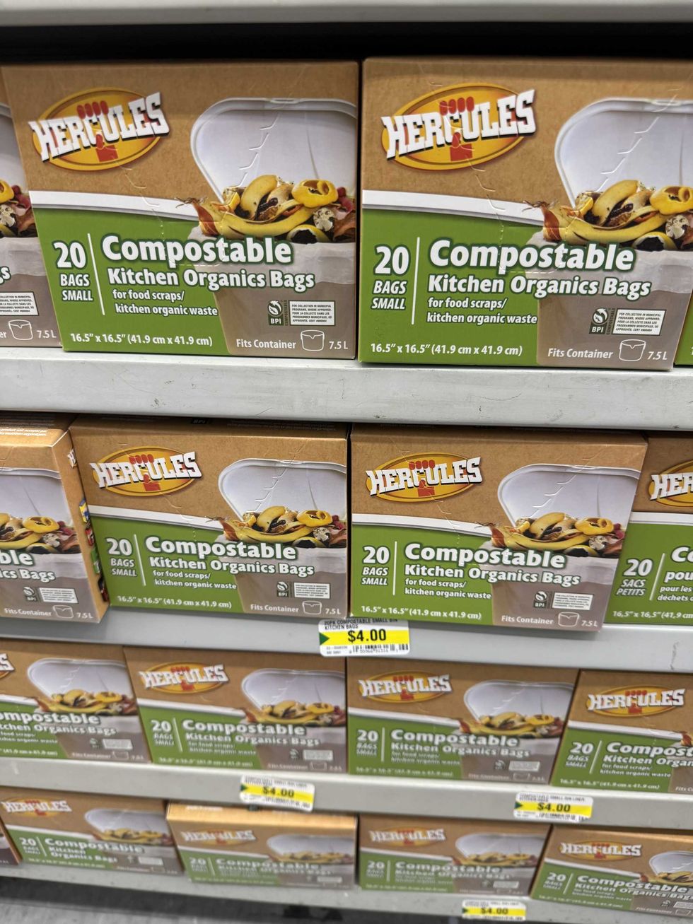 Brown and green boxes on store shelves that say Hercules 20 bags small compostable kitchen organics bags.