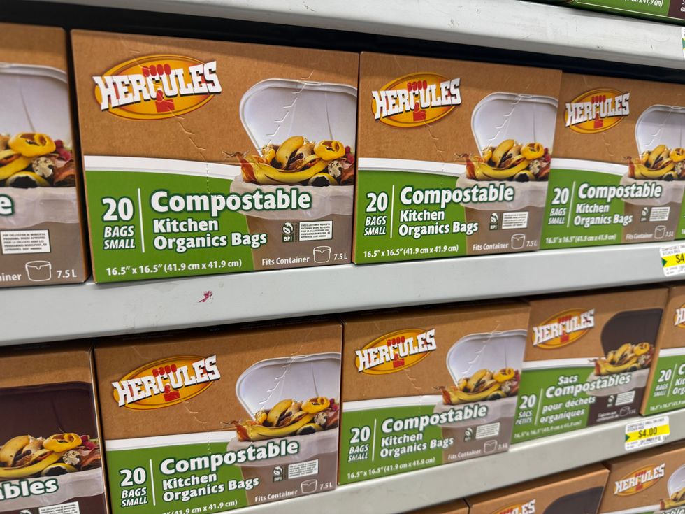 Brown and green boxes with a garbage bin on the front and a label that reads compostable kitchen organics bags.