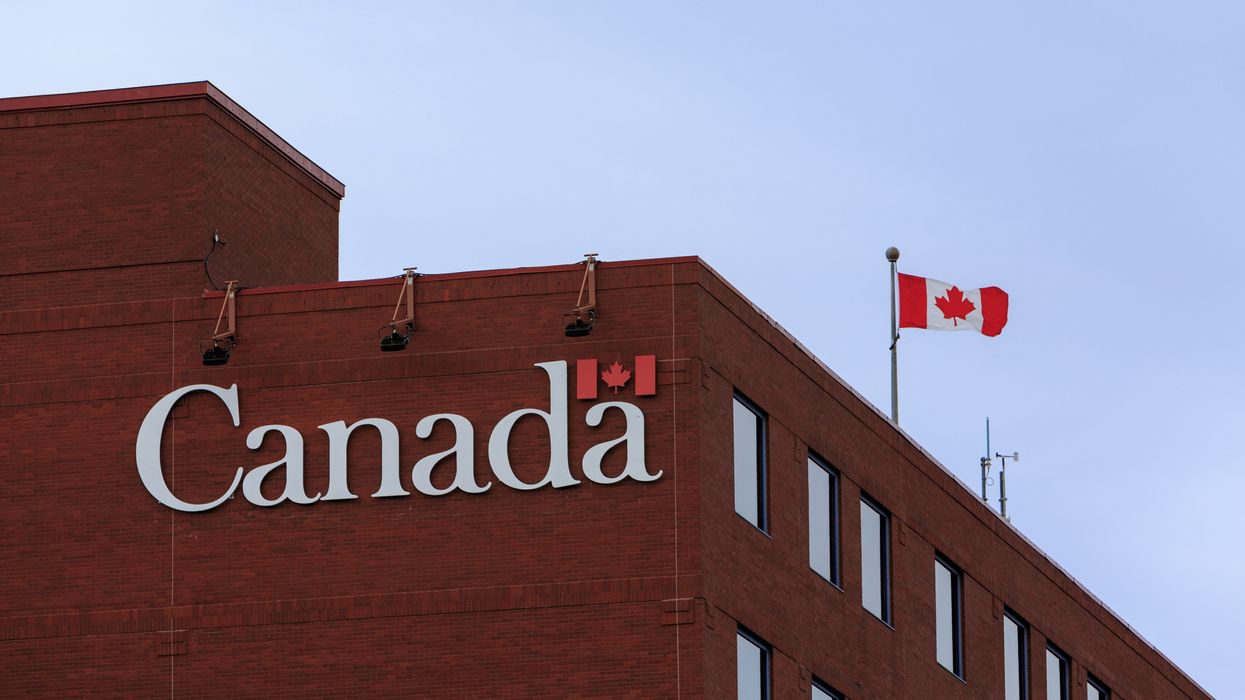 brown building with a government of canada sign on the side and a canadian flag on the roof
