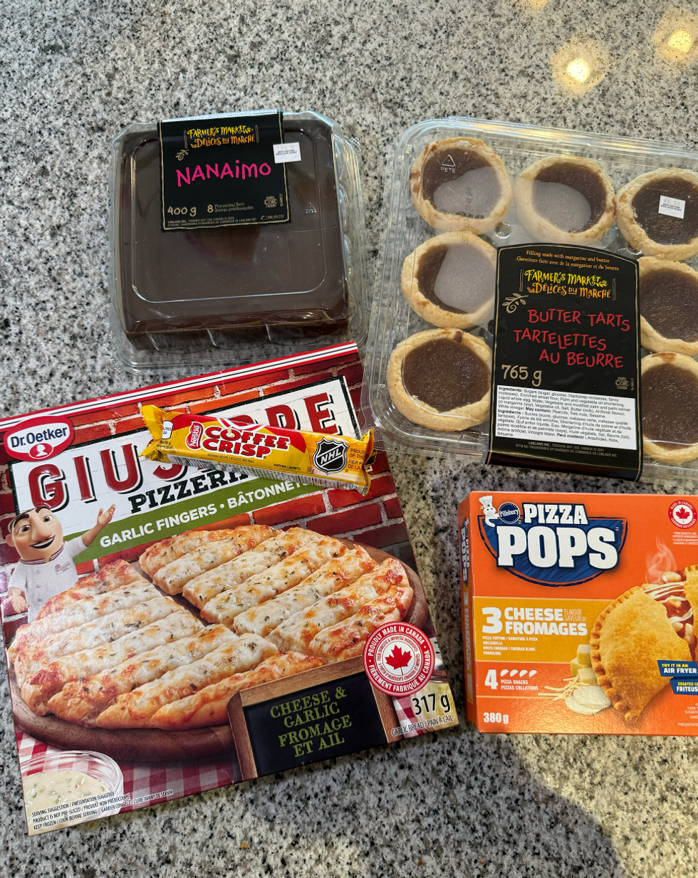 Butter tarts, Pizza Pops, garlic fingers, Nanaimo bars, Coffee Crisp on a table.