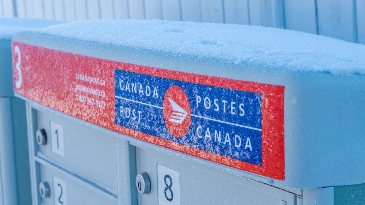 Canada Post mailbox covered in snow.