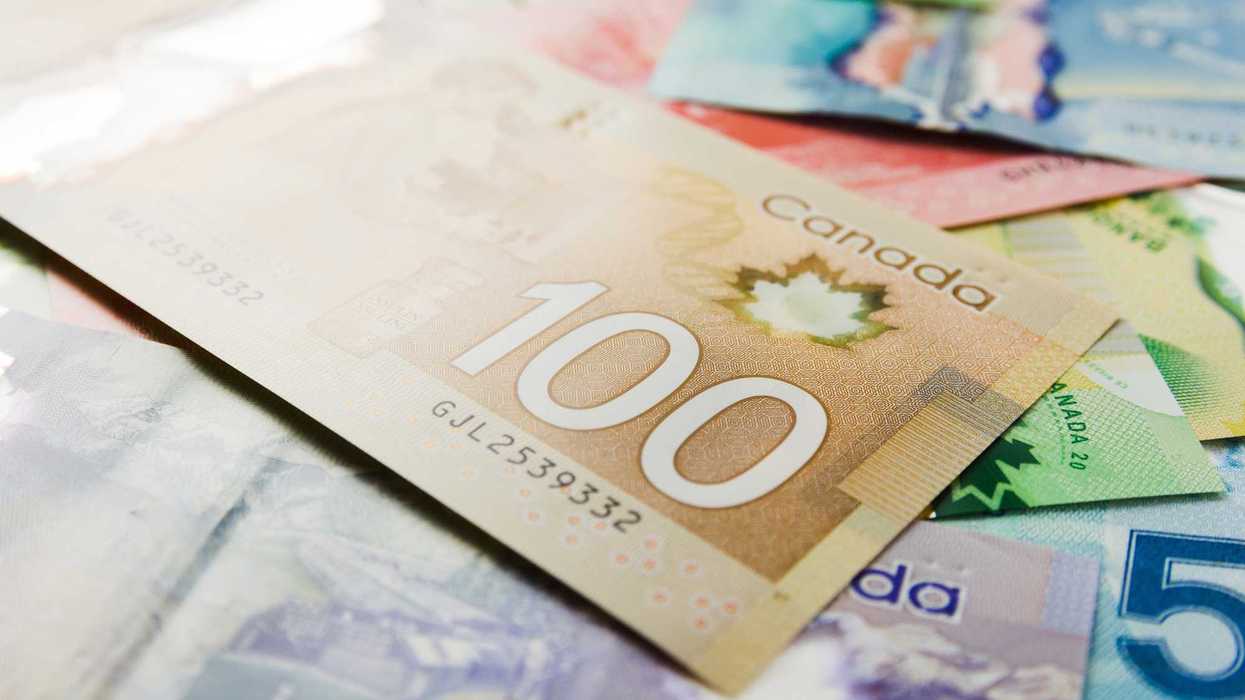 canadian $100 bill with other banknotes