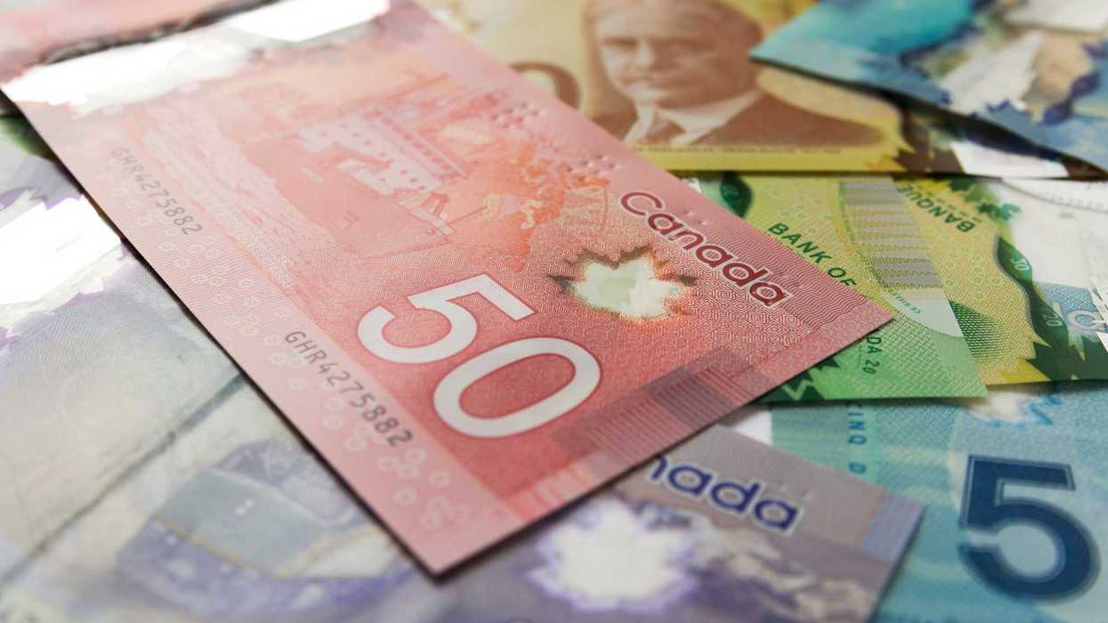 canadian $50 bill on top of $5, $10, $20 and $100 banknotes