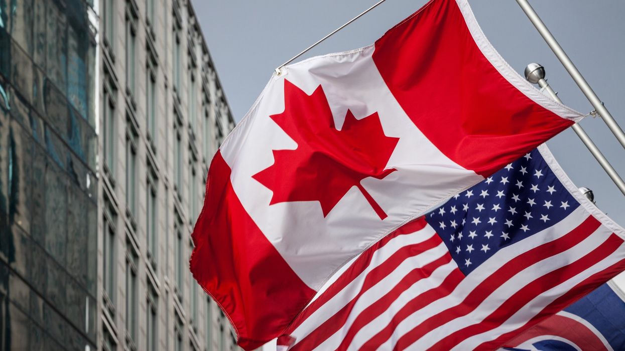 Canadian and U.S. flags on a building in Toronto.