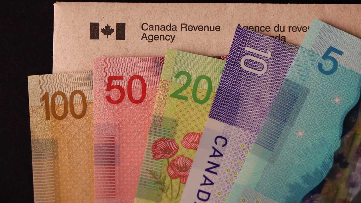 canadian banknotes on top of envelope with canada revenue agency and canadian flag logo