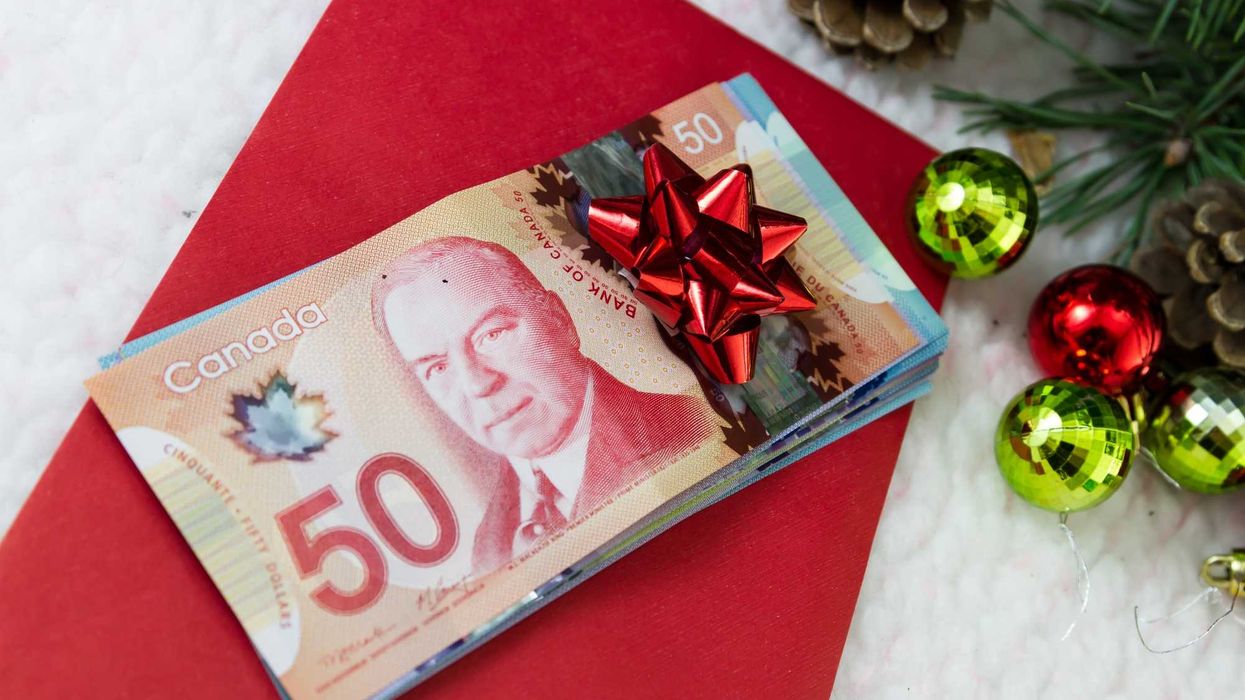 Canadian cash with a red envelope and Christmas decorations.