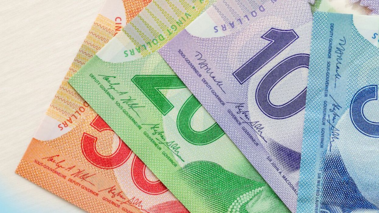 Canadian dollar banknotes on wooden background.