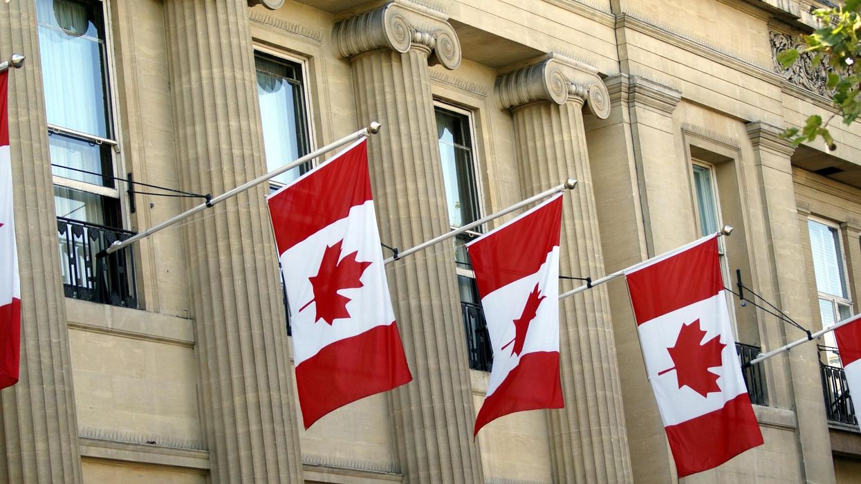 Canadian flags hang from a building.