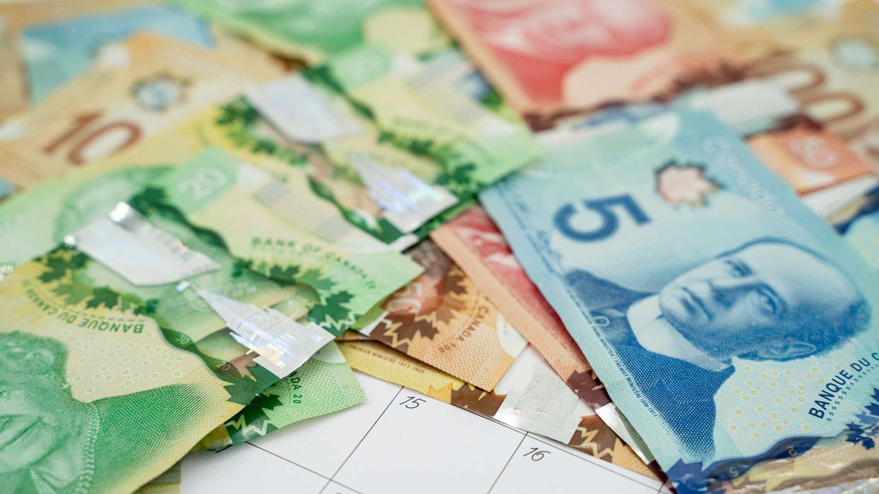Canadian money laid over a calendar.