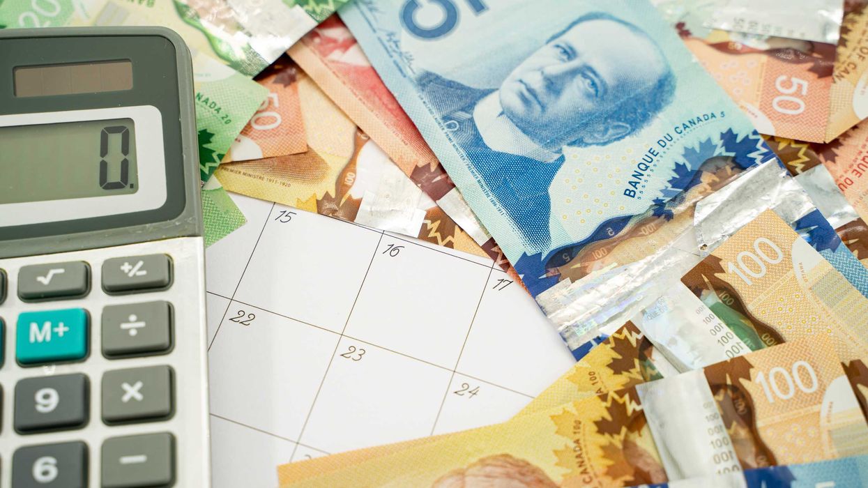 Canadian money laid over a calendar.