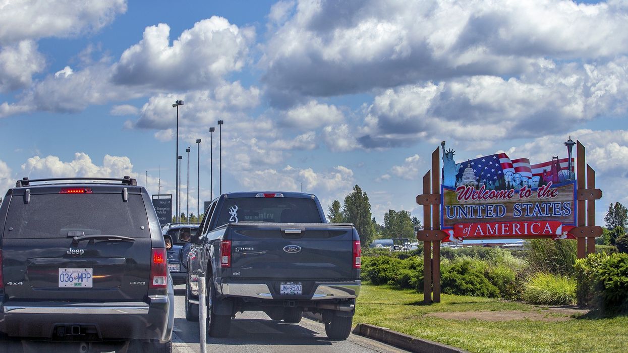 cars and welcome to the united states of america sign at canada-us border