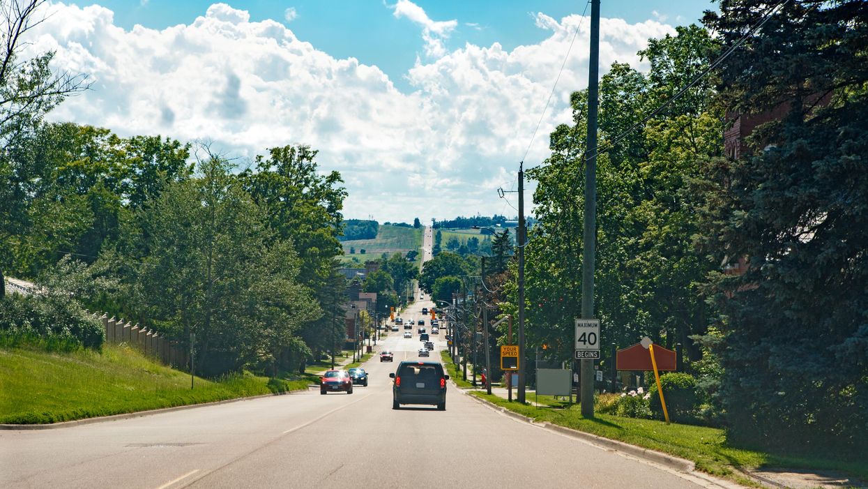 Cars driving on an Ontario road lined with trees.