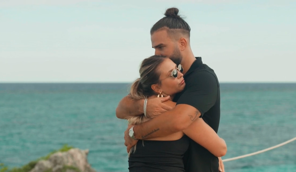 Catherine L. et Rapha\u00ebl d'Occupation Double se prennent dans leurs bras devant l'oc\u00e9an.