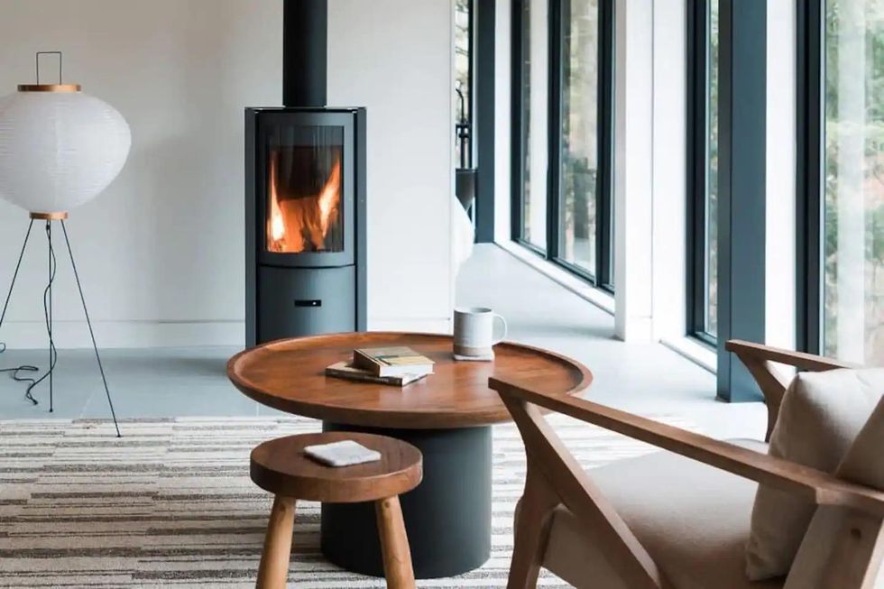 Chair and table in front of a fireplace.