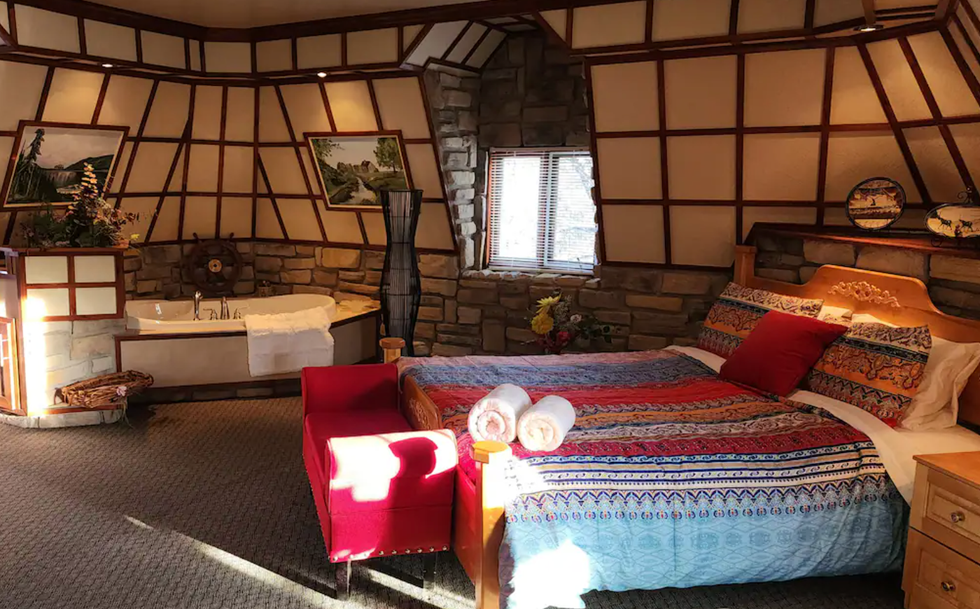 Chambre rustique avec un grand lit en bois et un bain.