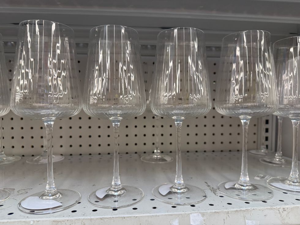 Clear wine glasses on a store shelf.