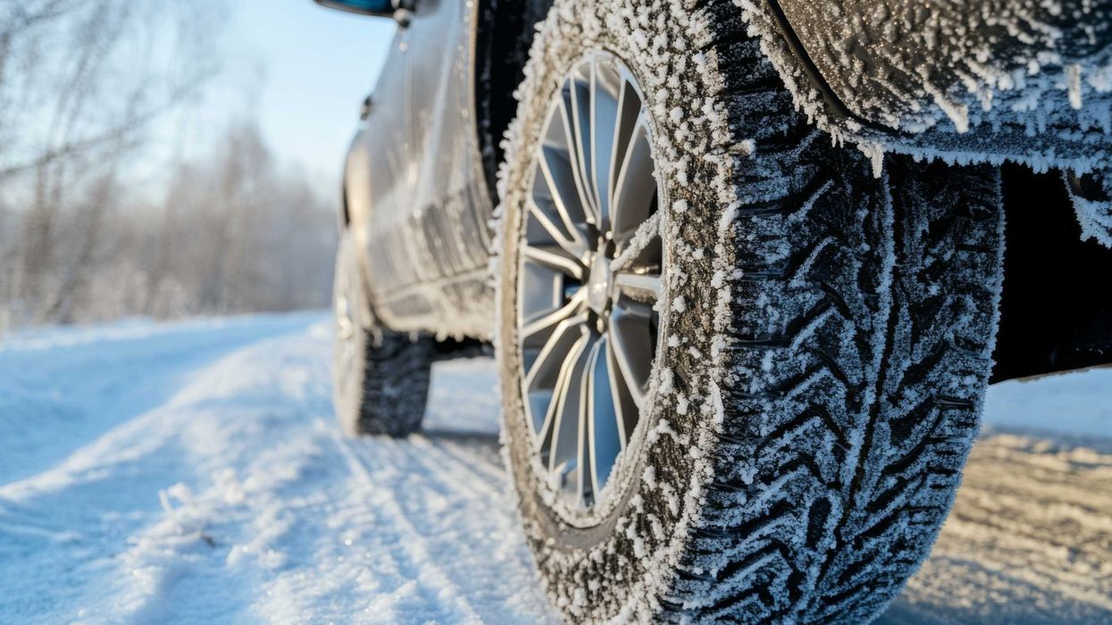 Closeup of a car with winter tires on a snowy road.