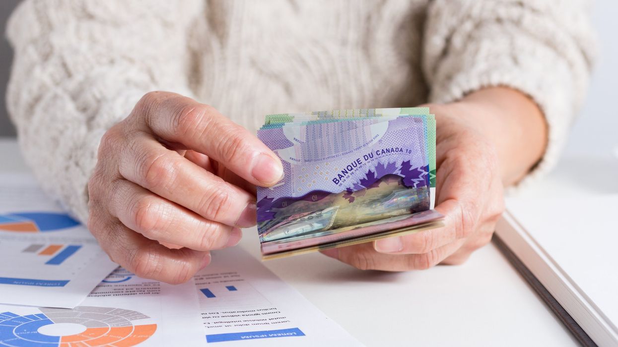 Closeup of hands counting Canadian money.