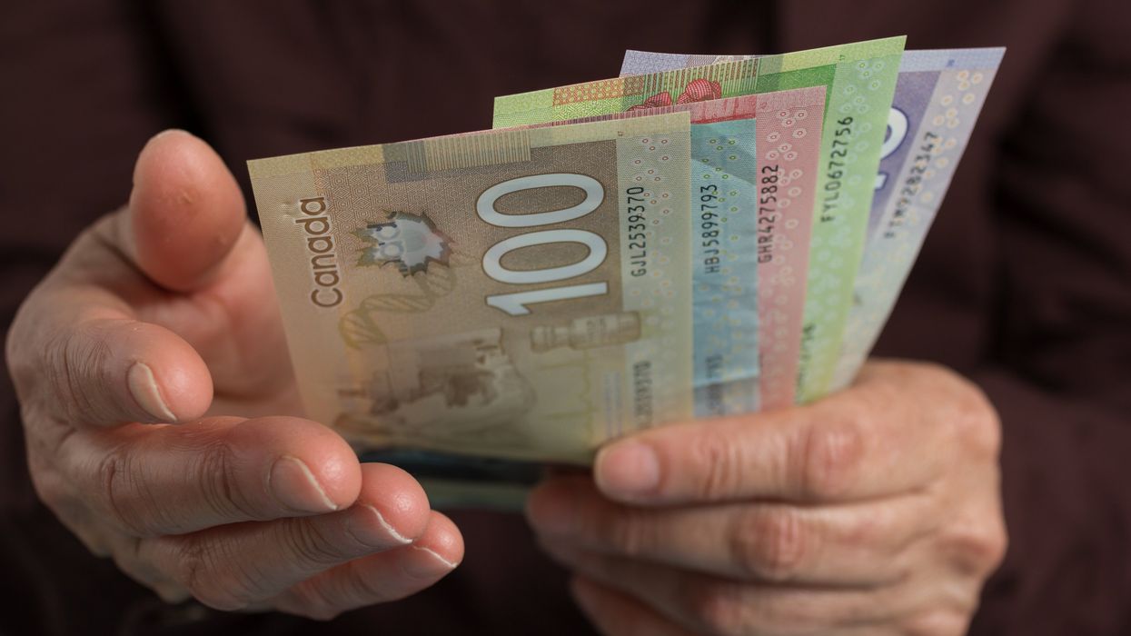 Closeup of hands holding Canadian money.