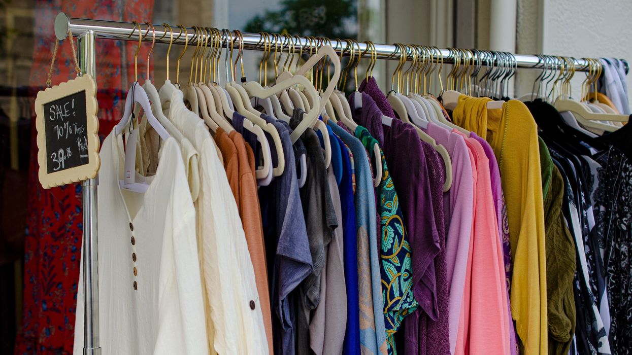Clothes on a rack that are for sale at a discounted price.