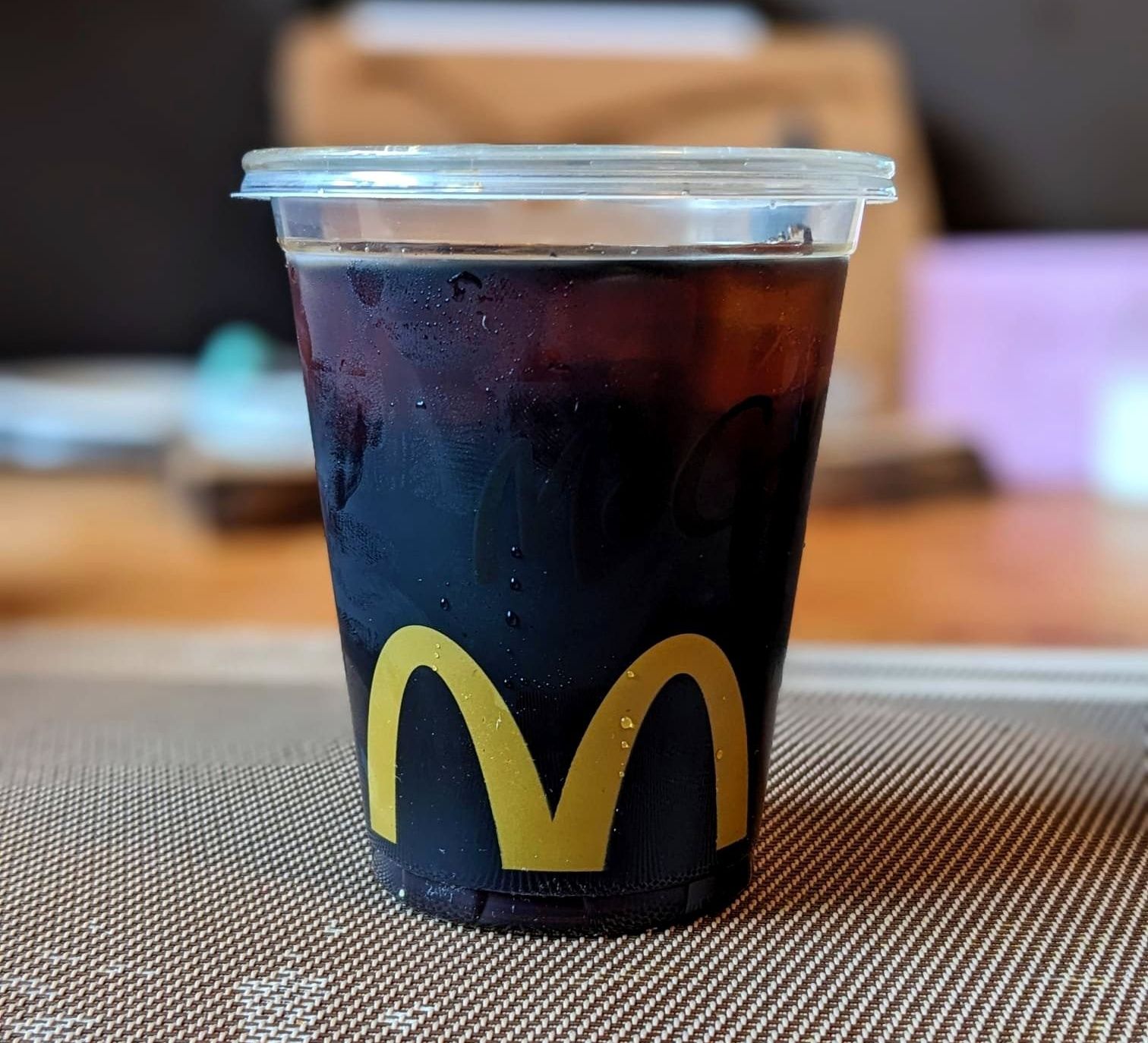 Cold brew from McDonald's in a clear plastic cup on a table.