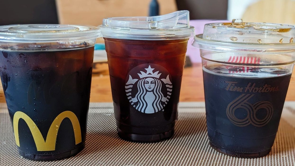 Cold brew from McDonald's, Starbucks and Tim Hortons in clear plastic cups on a table.