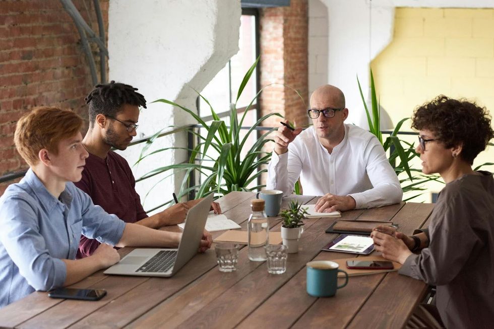Colleagues have a meeting at a table.