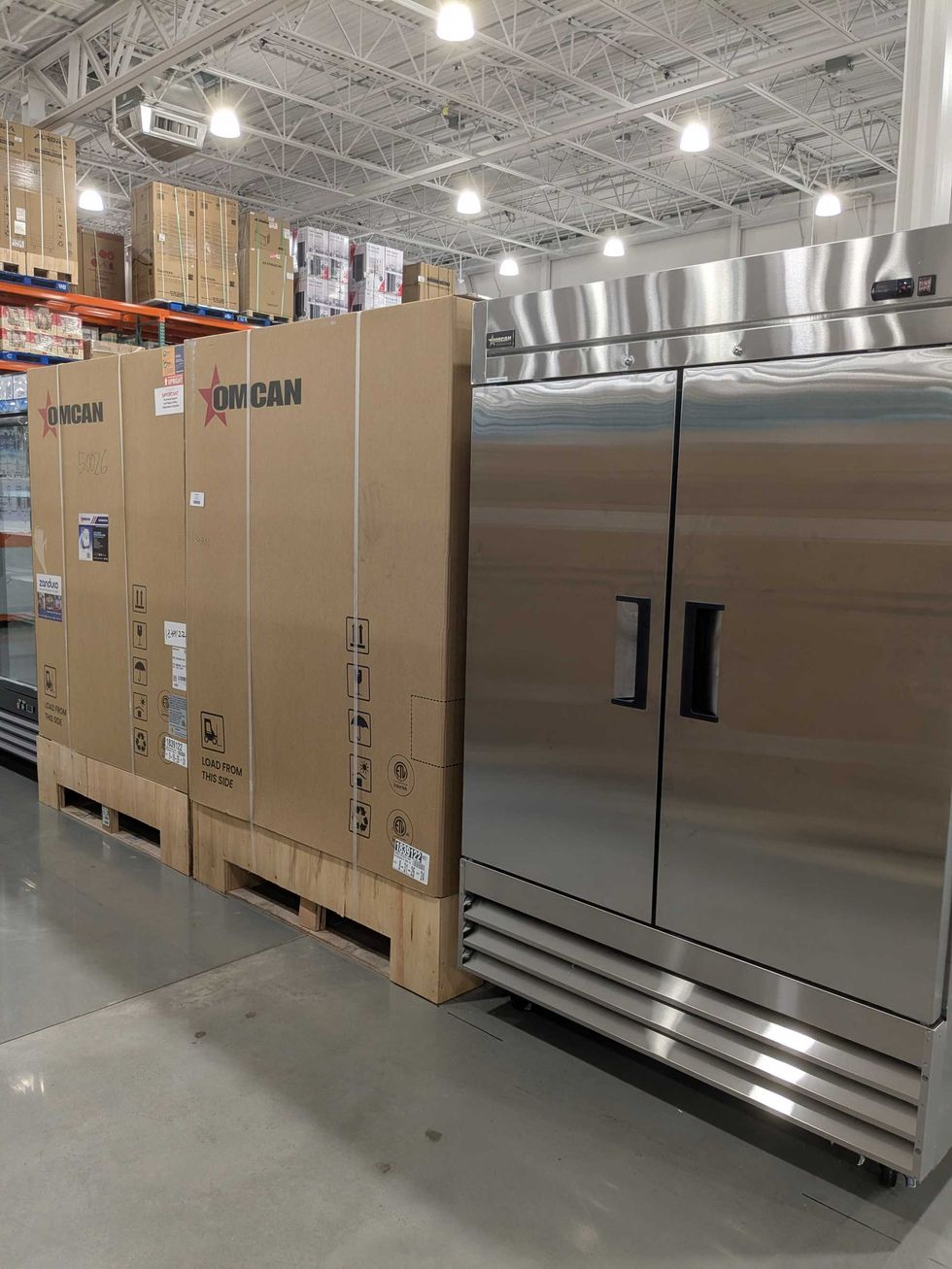 Commercial refrigerators and boxes in a warehouse aisle