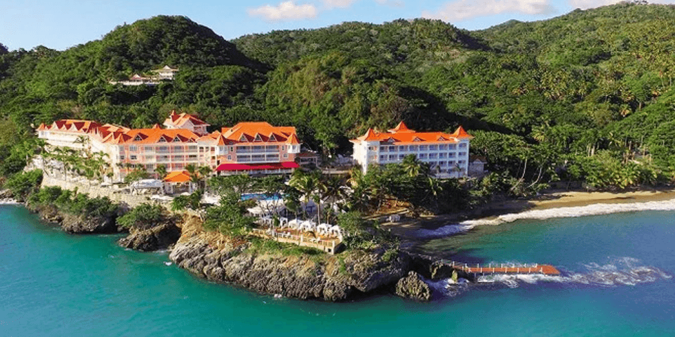 Complexe h\u00f4telier color\u00e9 perch\u00e9 sur une falaise entour\u00e9e de v\u00e9g\u00e9tation luxuriante avec vue sur la mer au Bahia Principe Escape Samana.