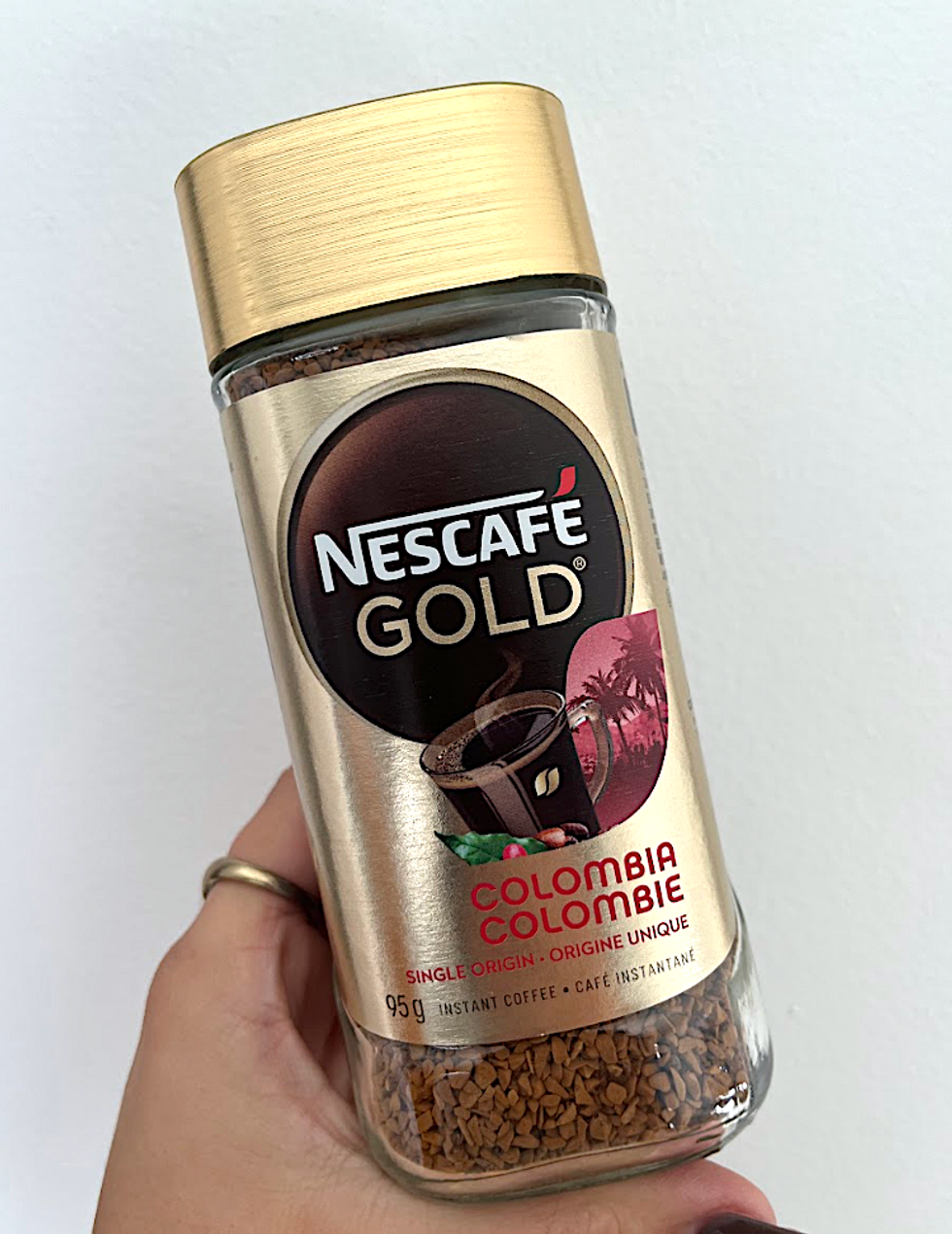 Contenant de caf\u00e9 instantan\u00e9 avec \u00e9tiquette dor\u00e9e de la marque \u200bNescaf\u00e9 Gold.