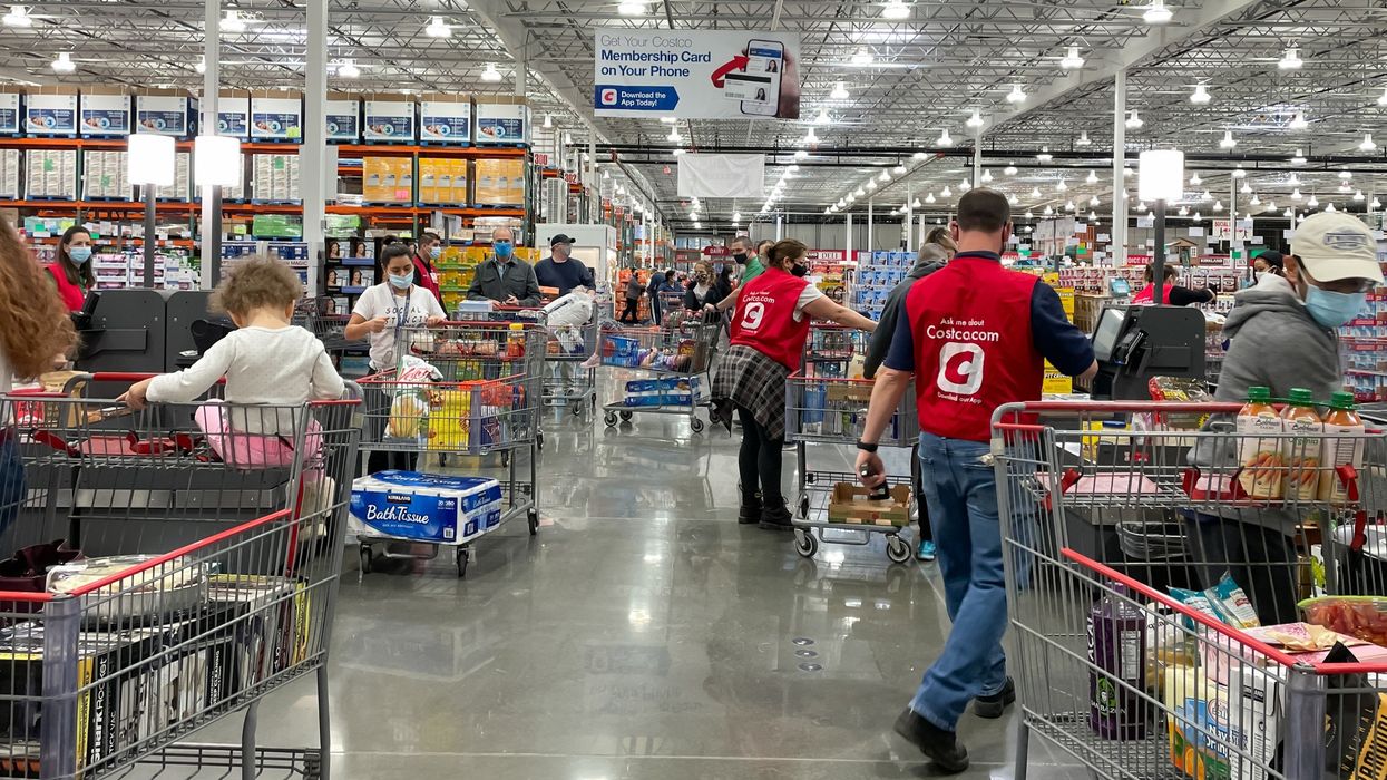 costco employees helping shoppers at the self-checkout