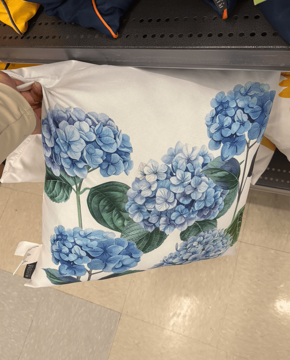 Coussin blanc avec imprim\u00e9 d\u2019hortensias bleus chez Tigre G\u00e9ant.