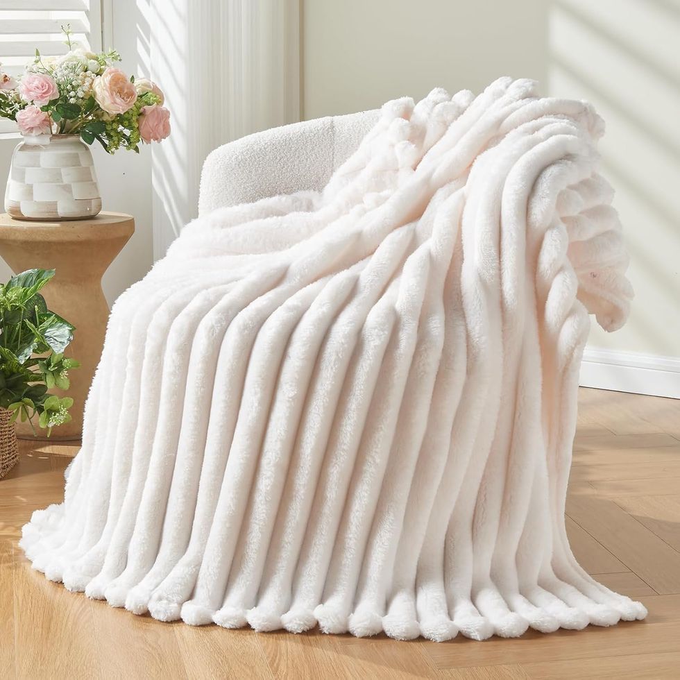 Couverture de lit en flanelle blanche pos\u00e9e sur une chaise.