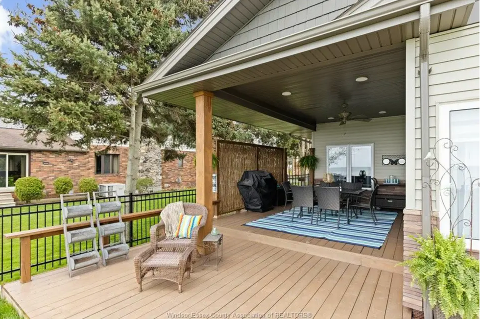Covered patio with striped rug and seating area.
